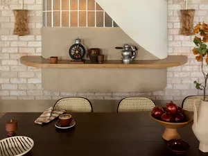 A modern dining room featuring wooden table, concrete base, and brick wall