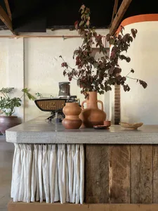 Industrial-style coffee shop counter with concrete surface and rustic wood paneling.