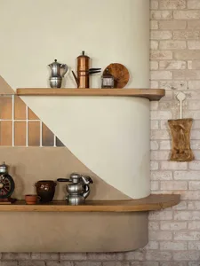 A minimalist kitchen with concrete walls and shelves.