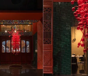 A modern restaurant interior with green tiles and red decorative elements.