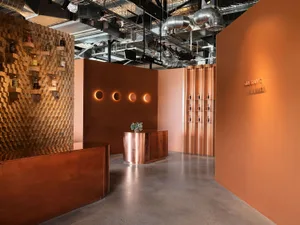 An industrial bar area featuring a metal counter and LED lighting on a brown background.
