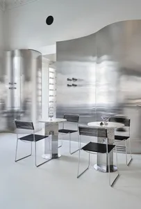 A modern restaurant interior featuring metallic surfaces and minimalist design elements.