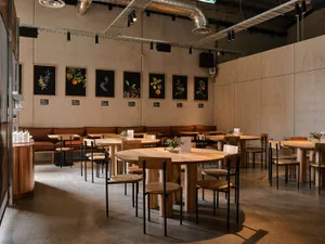 Industrial-themed restaurant interior with wooden tables and chairs
