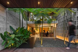 A modern interior space featuring concrete elements and natural greenery.
