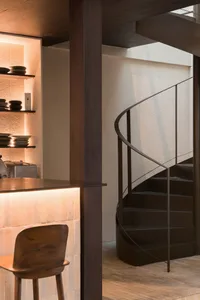 A modern interior featuring a stylish, industrial-inspired spiral staircase with metal railings.