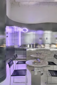 A modern metallic restaurant interior with reflective surfaces and industrial lighting.