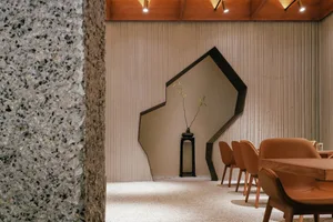 Modern restaurant interior with concrete walls and floor, geometric wall feature