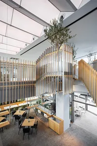 A modern restaurant interior featuring wooden tables, metal accents, and glass elements.