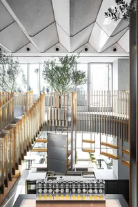 Modern-themed coffee shop interior with wood accents, metal railings, and glass partitions.