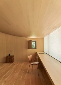 A minimalist office space featuring wooden paneling and furniture.