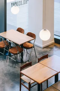 A modern restaurant space featuring wooden tables and chairs.