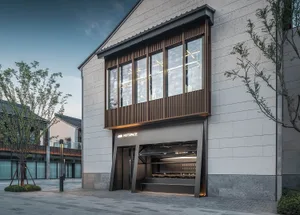 Modern storefront with concrete facade, glass windows, and metal entrance