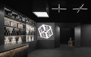 A modern retail store with thick black paneling and a large black digital monitor.
