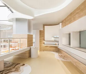 A minimalist bakery interior featuring white marble and travertine surfaces.