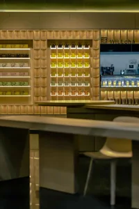 Modern cafe interior with wooden shelves and lighting.