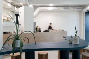 A modern coffee shop interior with concrete and wooden elements.