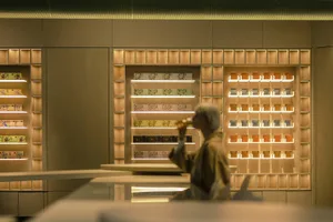 A modern coffee shop with wooden shelves displaying tea products.