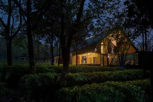 A modern residential exterior with wooden elements at dusk.