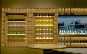 A modern retail display featuring organized shelves with boxes of products and a counter with cups.