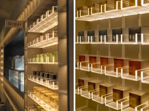 A modern retail display featuring clear glass shelves stocked with various products.
