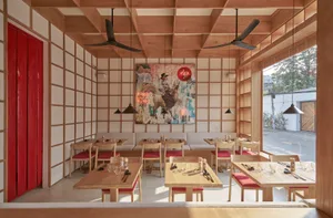 A restaurant interior with wooden furniture, tables, chairs, and a decorative painting on the wall.