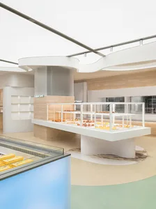 A modern bakery interior with light-colored marble countertops and concrete elements.