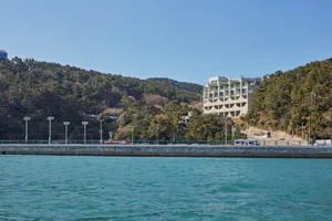 A modern resort building with concrete and glass exteriors surrounded by greenery.