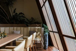 A cozy coffee shop interior with wooden furniture and a large window.