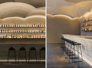 Modern bar interior featuring concrete walls and shelves illuminated with soft lighting.