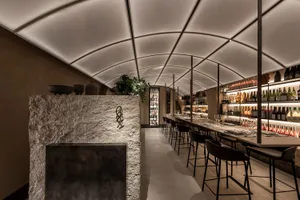 Modern restaurant bar featuring stone, concrete, and metal elements.