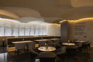 現代餐廳室內，混凝土天花板呈現圓形造型，搭配溫暖的昏暗燈光。