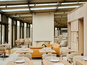 A modern restaurant interior with minimalist design and neutral-toned furniture and decor.