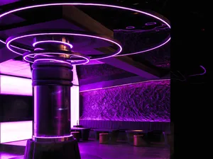 Industrial-style bar and dance floor with metallic columns and concrete accents.