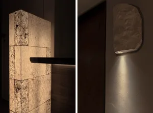 A minimalist interior design featuring a stone wall and wooden floor.