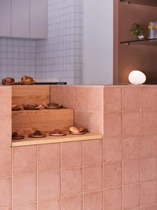 Minimalist retail space featuring ceramic tiles on the wall and floor, showcasing a sleek and contemporary design.