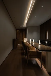 Modern dining room featuring wooden tables and chairs, creating a contemporary and minimalist atmosphere.