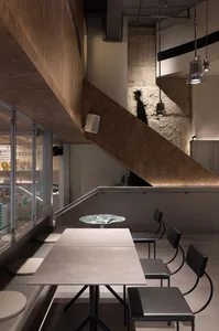 Industrial cafe interior with concrete walls and minimalist design.