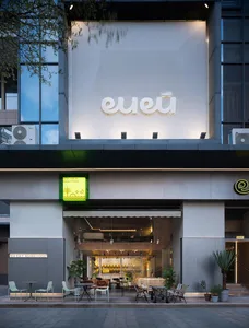 A modern building with a facade made of glass and cladding materials.