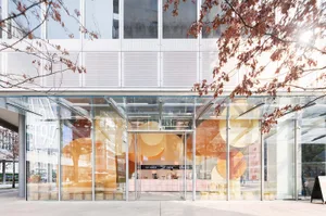 Modern coffee shop exterior with glass walls and large windows.