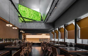Interior of a modern restaurant featuring steel, glass, and concrete materials.