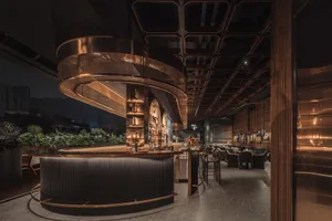 Industrially-themed restaurant with metallic counter and seating area.