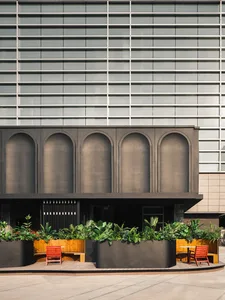 Modern building exterior with metallic architecture and green planters.