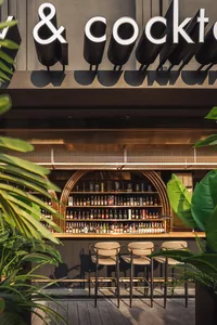 A modern bar interior with metal, wood, and glass materials.