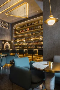 A modern bar interior with mid-century design elements featuring a metallic finish.