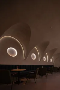 Interior of a modern cafe with concrete walls and circular cutouts.