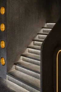 A modern staircase with concrete steps illuminated by built-in lighting.