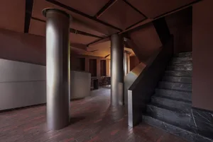 Modern hotel lobby with metallic columns and marble staircase