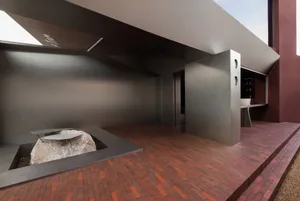 Modern interior space featuring black metal structures and a stone element.