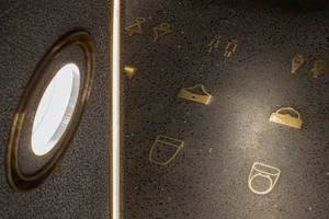 Modern public space with terrazzo tile flooring, featuring symbol icons for restrooms and other amenities.