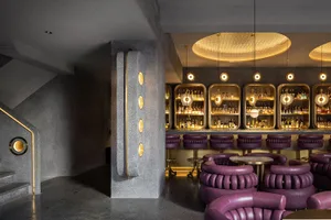 A modern restaurant bar with concrete and metal finishes.